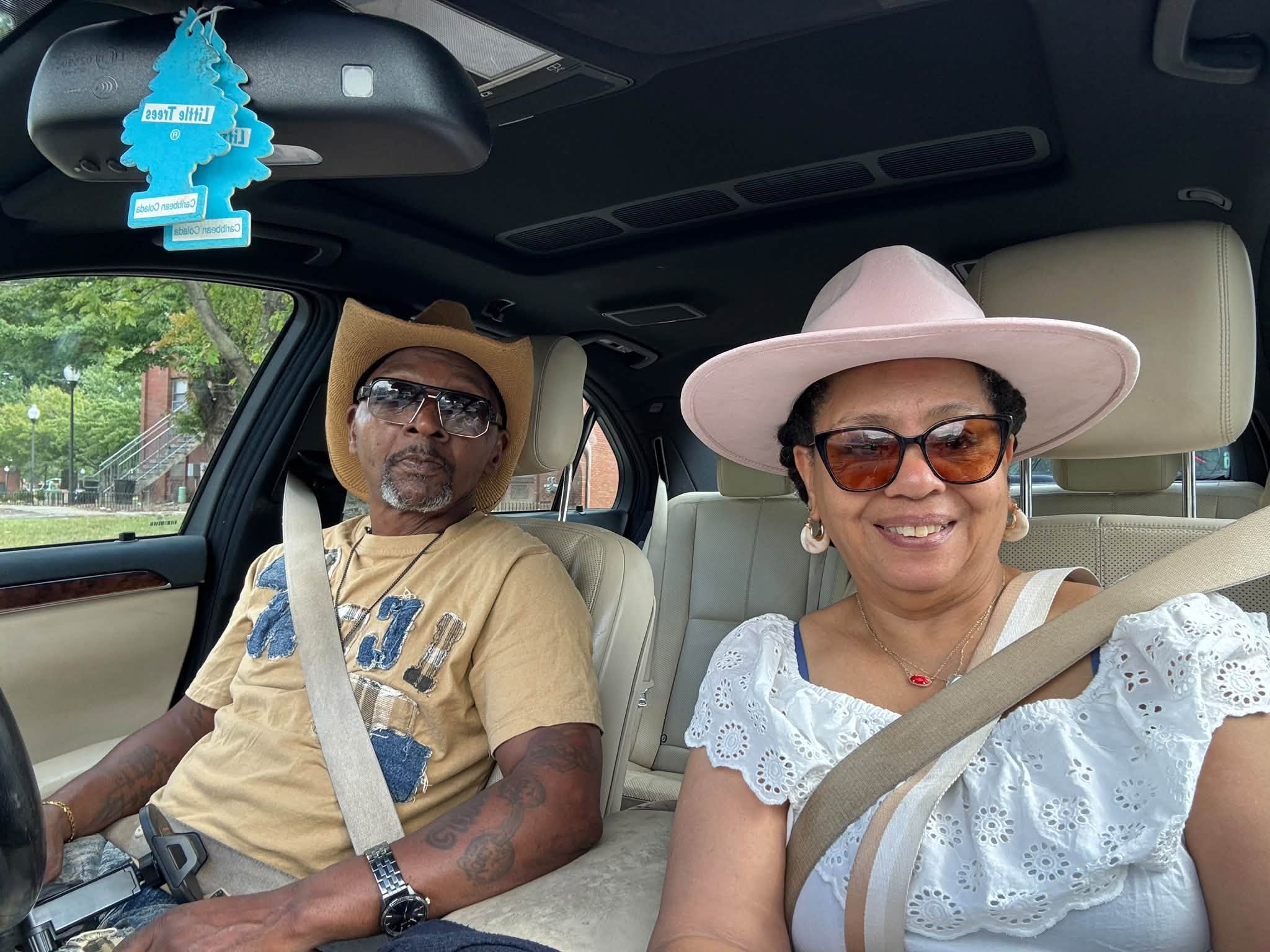 James and Shawn seated together in their car, both wearing cowboy-style hats