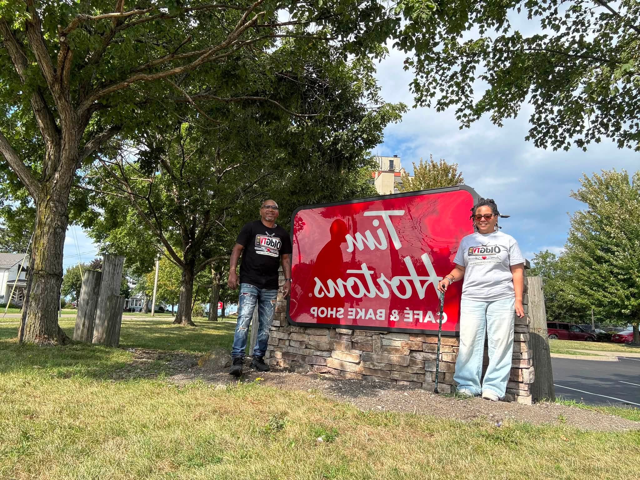 James and Shawn wearing OLDGTV shirts beside a Tim Hortons sign